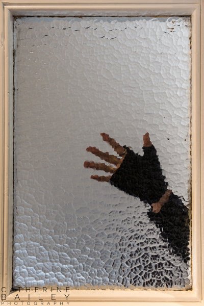 Gloved hand behind glass window | Catherine Bailey Photography