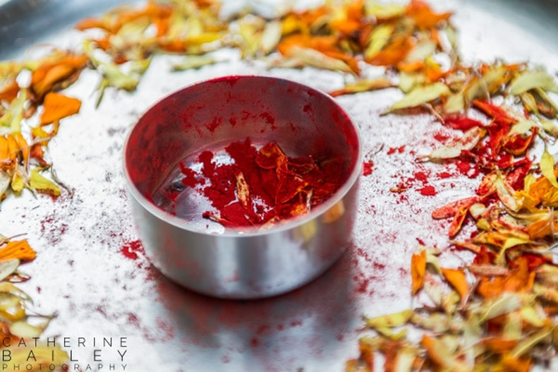 Spices in dish surrounded by marigold petals | Catherine Bailey Photography
